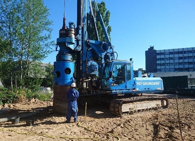 Blick auf die Baustelle der LHKW-Bodensanierung in Berlin, mit Maschinen und Arbeitern im Einsatz.