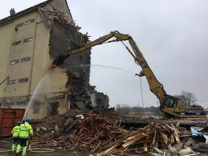 Baustelle des Rückbaus der BayWa AG in München, mit schwerem Gerät und Baustellenabsperrungen im Vordergrund.