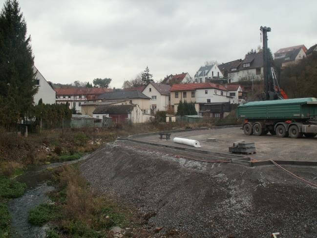 Sanierungsarbeiten an der Sattler Altlast in Schonungen, mit Fokus auf die umgebende Landschaft und Baustelleneinrichtungen.